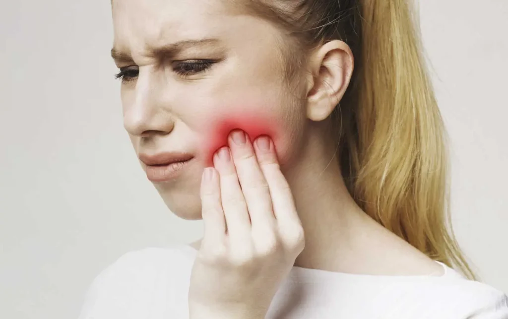 Woman with severe tooth pain needing emergency dental care at Beamsville Smiles Family Dentistry
