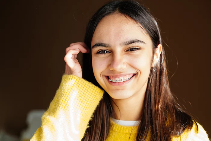 Smiling teen with braces receiving laser dental treatment at Beamsville Smiles Family Dentistry
